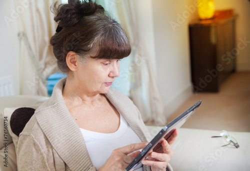Pension age woman searching in internet on tablet device