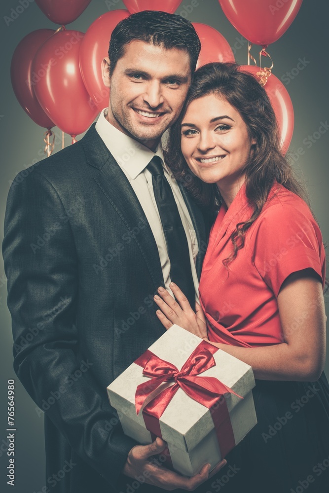 Happy couple with balloons and gift box Happy couple with balloons and gift box
