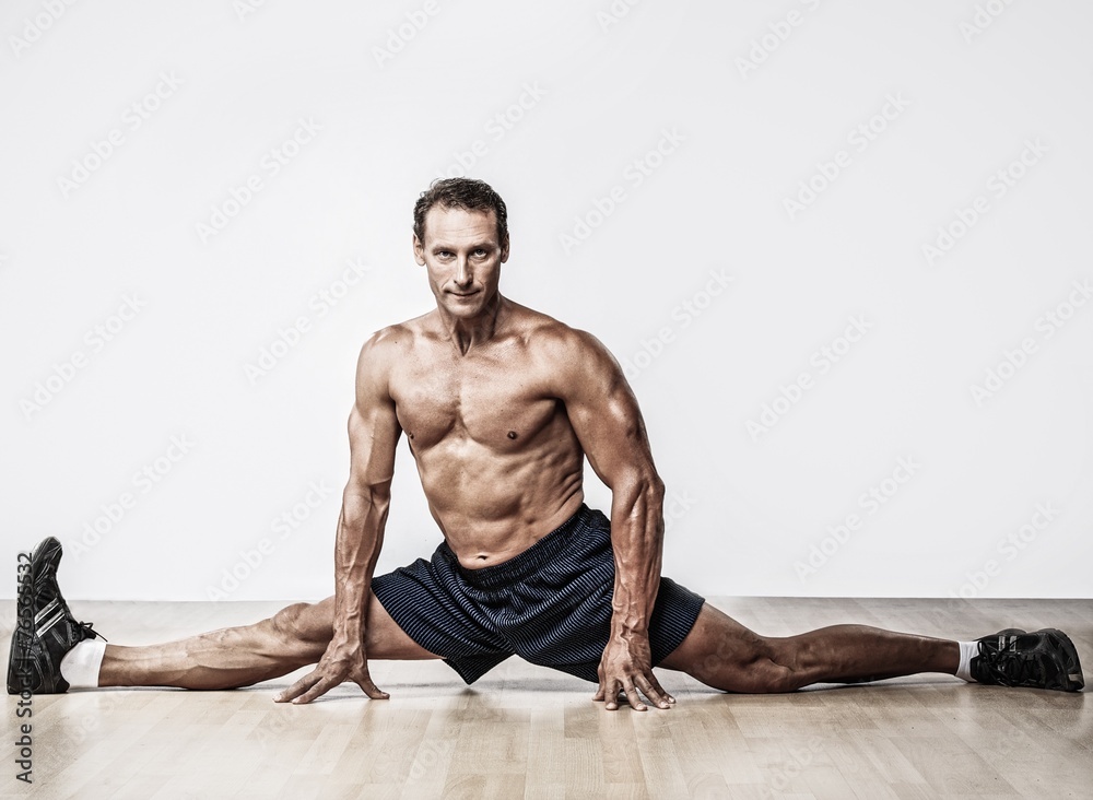 Handsome muscular man doing splits Handsome muscular man doing splits