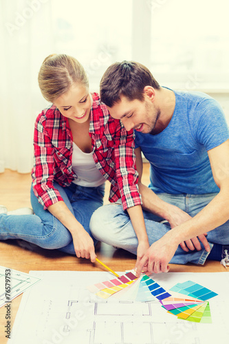 smiling couple looking at color samples at home