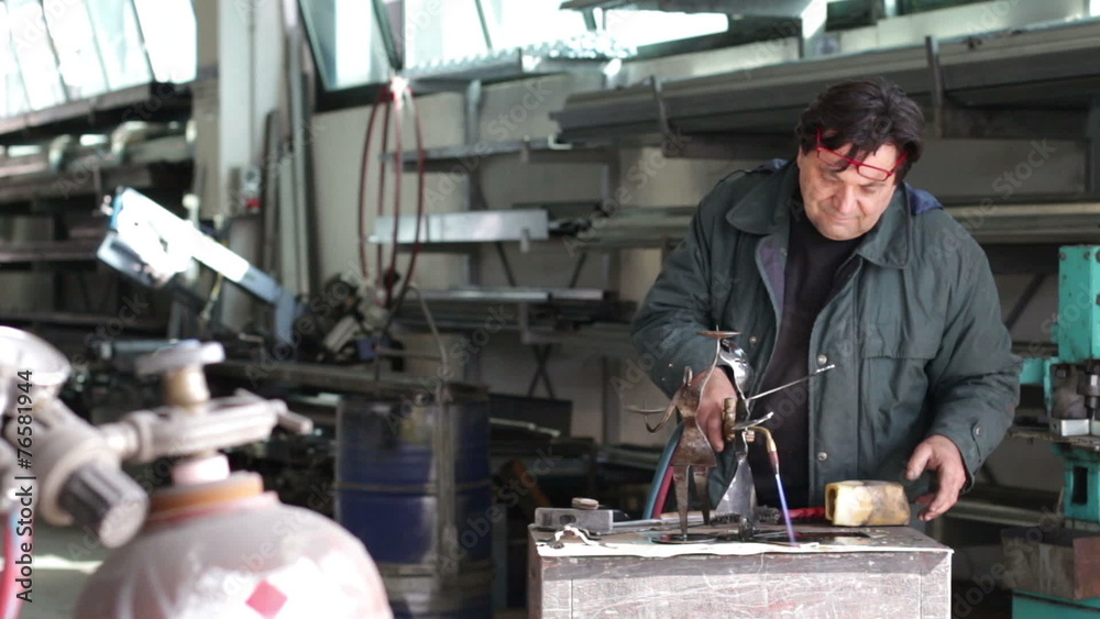 craftman working with the blowtorch - dolly craftman working with the blowtorch - dolly