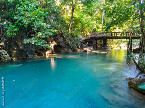 River flowing through from Erawan waterfall in deep forest of national park  Thailand with a bridge background.