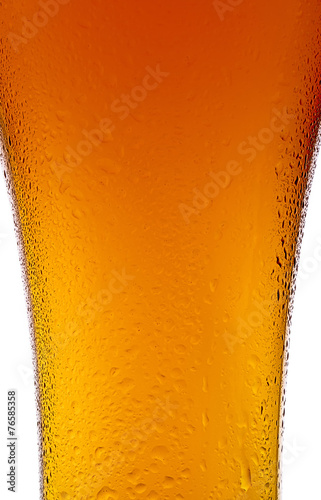 Beer cup with water droplets close-up on white background.