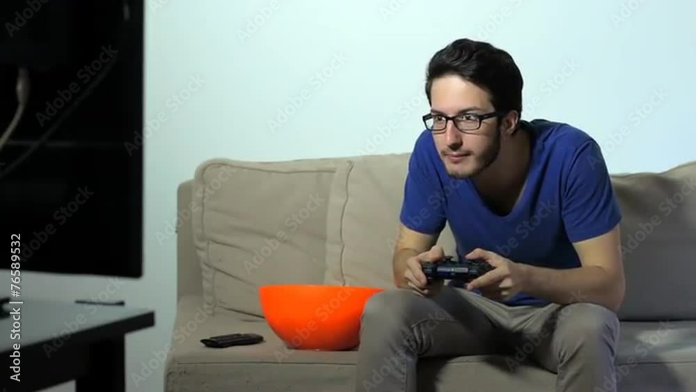Man Playing Videogames with Gamepad while eating popcorn Man Playing Videogames with Gamepad while eating popcorn