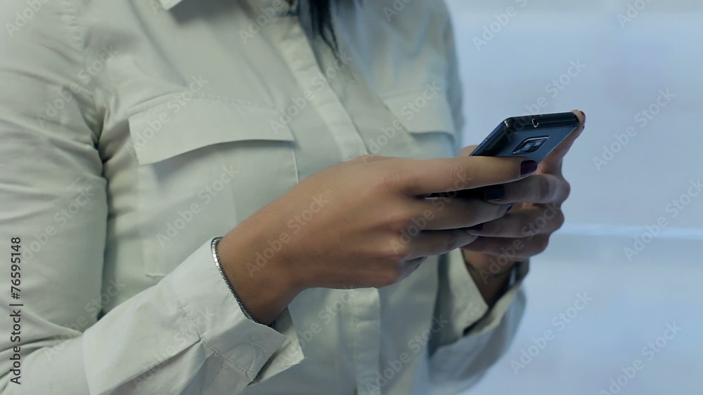 Young beautiful woman writes an SMS to your mobile phone Young beautiful woman writes an SMS to your mobile phone