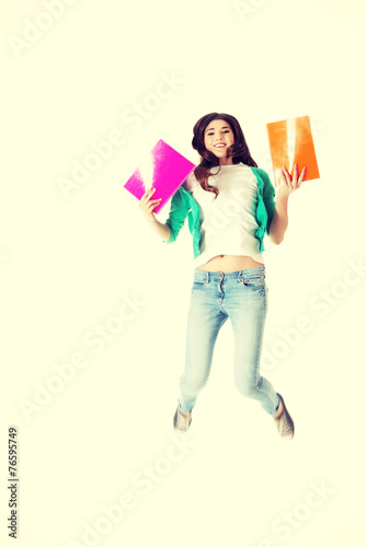 Young student jumping with files, workbook.
