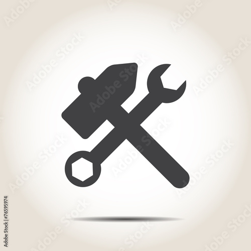 Hammer and wrench on a gray background