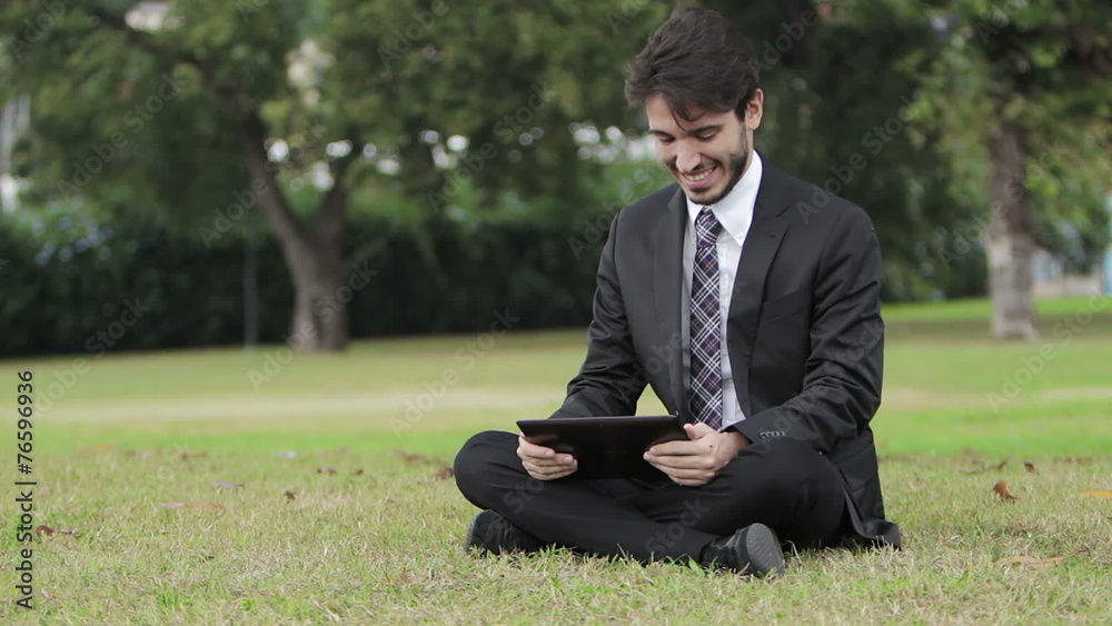 Young businessman at the park working with tablet Young businessman at the park working with tablet