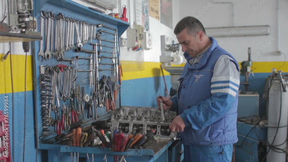 Auto mechanic repairing a car engine - dolly Auto mechanic repairing a car engine - dolly