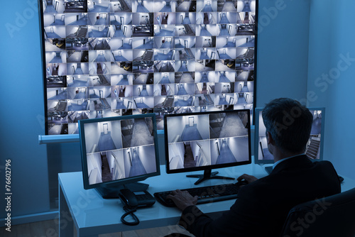 Man In Control Room Monitoring Cctv Footage photo