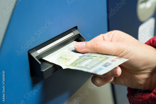 Woman Inserting Cash Into Machine