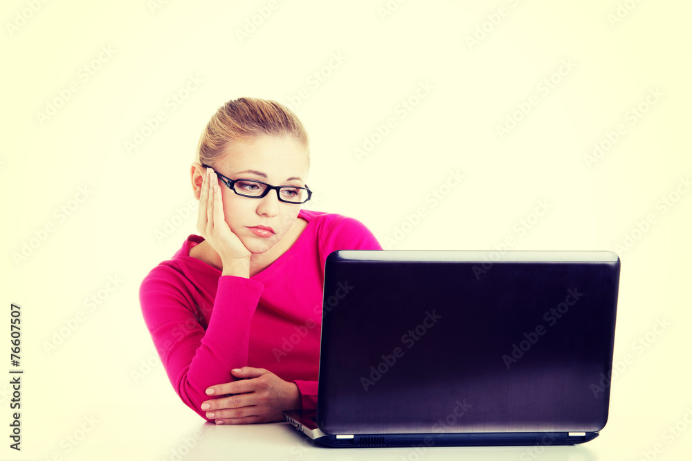 Bored, sad woman sitting in front of laptop. Bored, sad woman sitting in front of laptop.