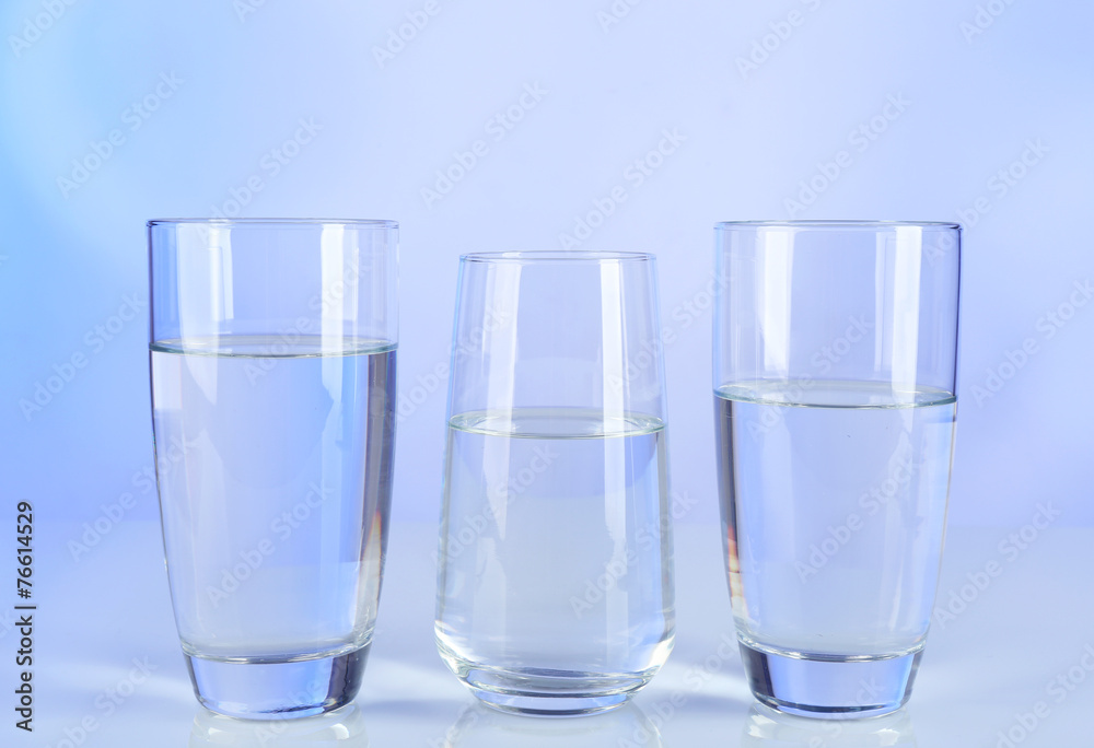 Glasses of water on table and colorful background Glasses of water on table and colorful background