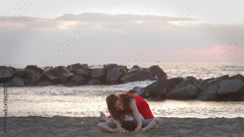 Sexy young wet couple embrace on the beach