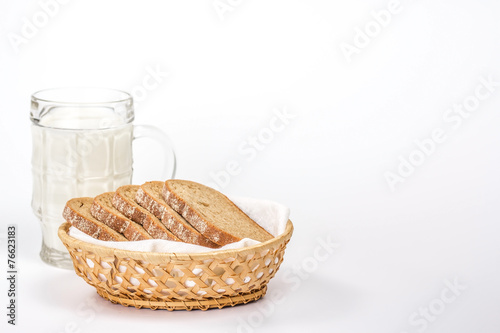isolated basket of bread and glass of milk