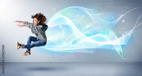 Cute teenager jumping with abstract blue scarf around her