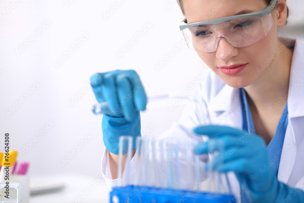 Woman researcher is surrounded by medical vials and flasks Woman researcher is surrounded by medical vials and flasks