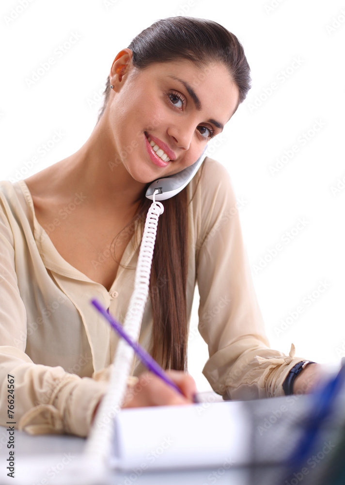 Young businesswoman sitting at the desk and talking on phone Young businesswoman sitting at the desk and talking on phone
