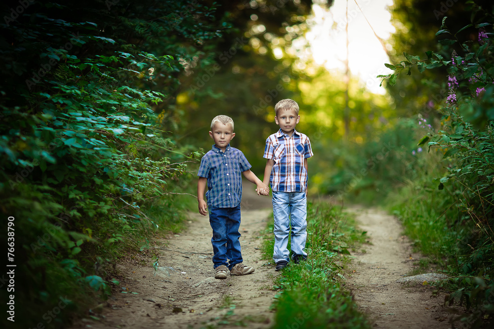 Two brothers hugging each other outdoor, smiling and laughing