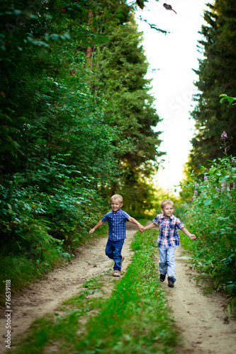 Two brothers hugging each other outdoor, smiling and laughing