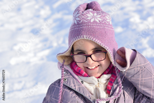 Little girl with glasses posing in the snow