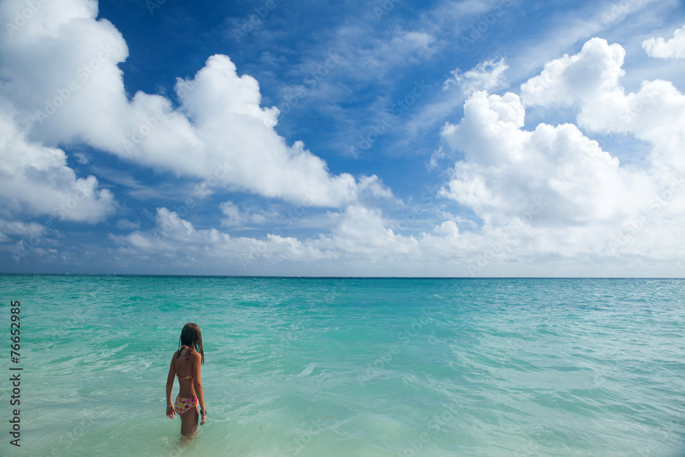 Obraz premium Girl enjoys summer day at the tropical beach.