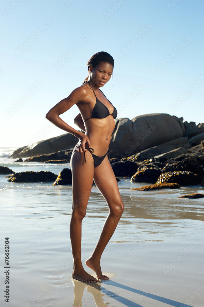 Beautiful african american woman in black bikini at the beach Stock Photo