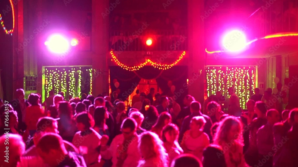 People dancing in spot light rays lumiere on a disco