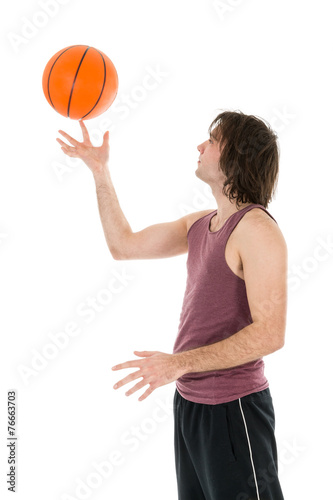 Young man with spinning basketball at his forefinger