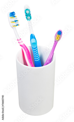 three toothbrushes in ceramic glass