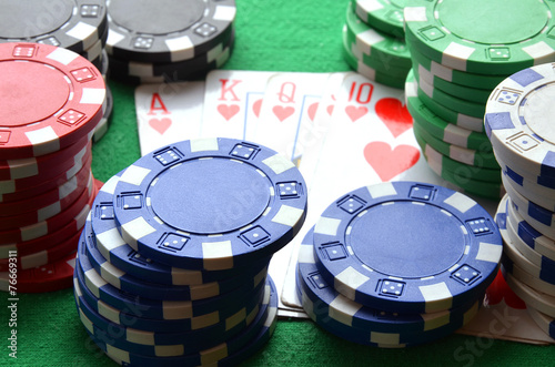 Red, blue, green, white and black poker chips and royal flush