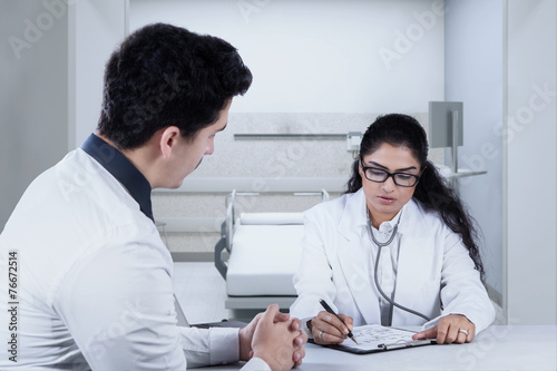 Doctor writing something for her patient
