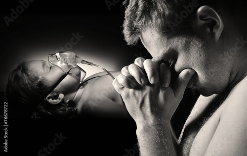 Obraz na płótnie Father prays for the health of seriously ill daughter. w salonie