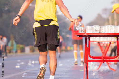 Runner take a water in a marathon race