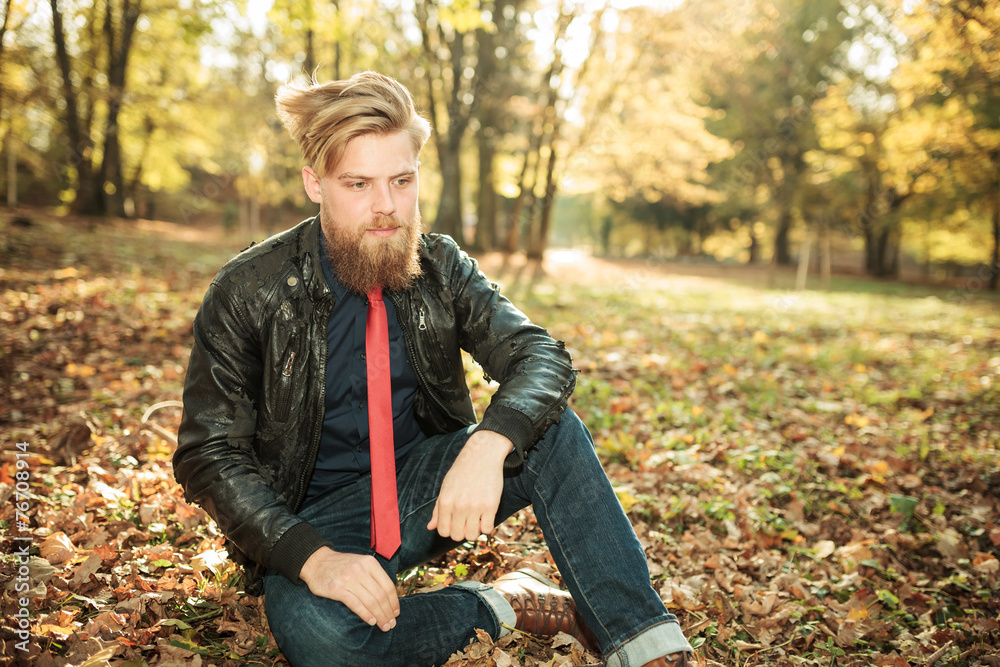 Young casual man looking down while sitting Young casual man looking down while sitting