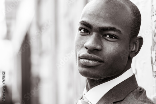 Handsome black man wearing suit in urban background © javiindy