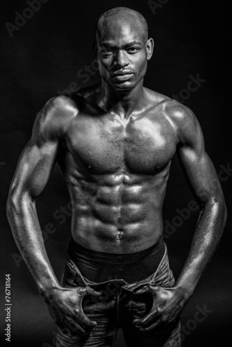 Athletic black man on black background