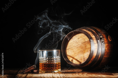 Kieliszek alkoholu i palenie szlachetnego cygara na czarnym tle
