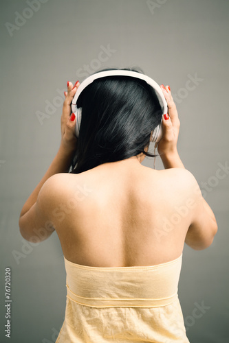 Indian girl listening over headphone