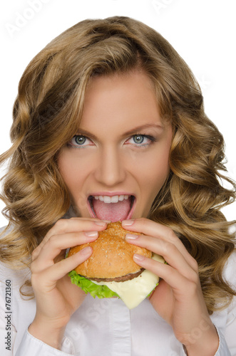 Beautiful young woman taking bite of hamburger