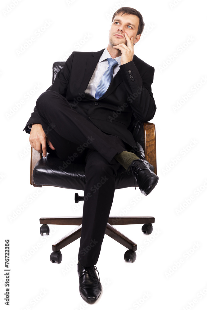 Thoughtful businessman sitting in an armchair and looking up