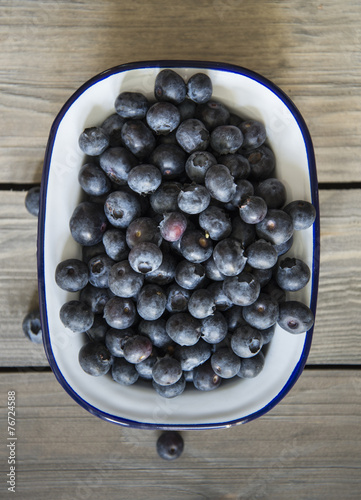 Blueberries in rustic kitchen setting with old wooden background photo