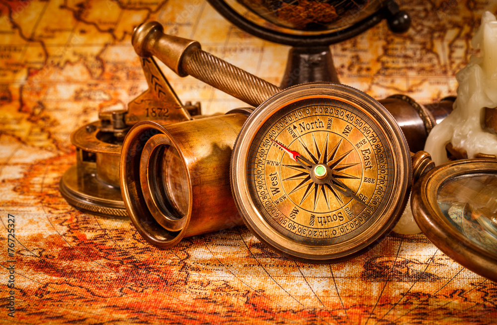 Vintage magnifying glass lies on an ancient world map wall mural ...