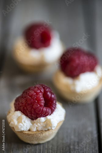 Raspberry tartlets on rustic wooden kitchen  background photo