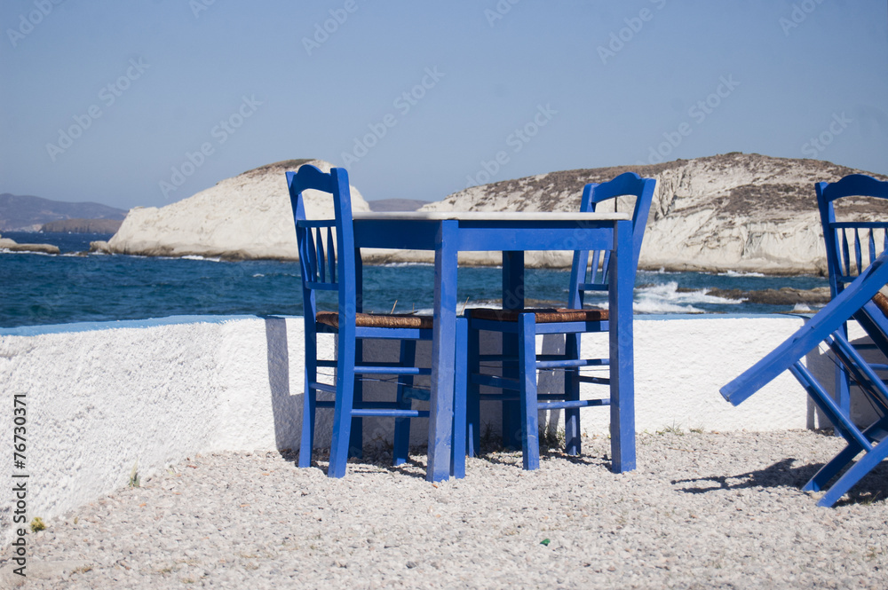Ble chairs and table at sea side restaurant