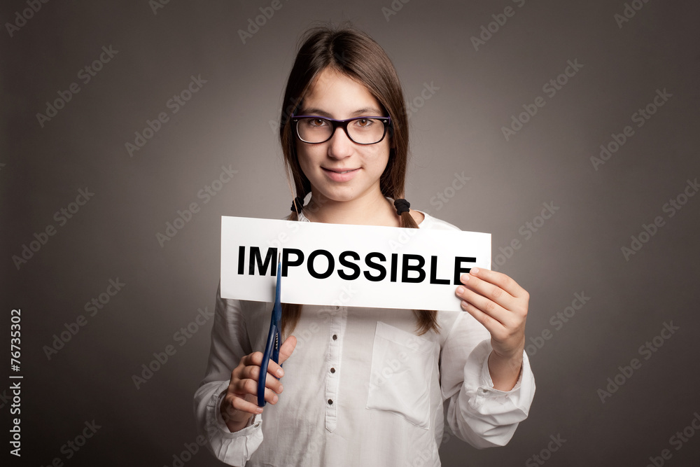 young girl cutting impossible word with scissors young girl cutting impossible word with scissors