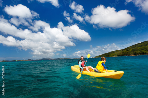 Family kayaking at tropical ocean