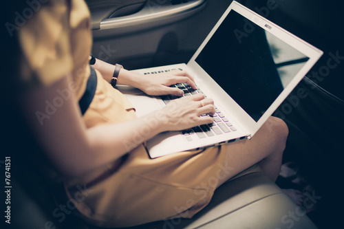 businesswoman with document and laptop in car