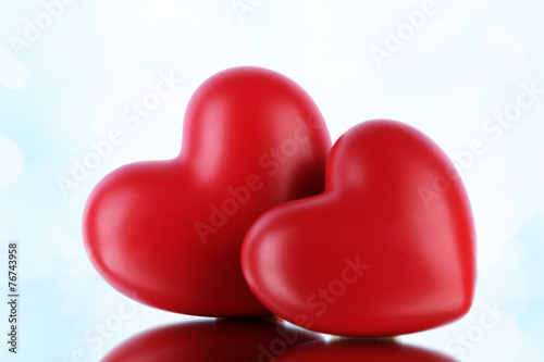 Red hearts on light background © Africa Studio