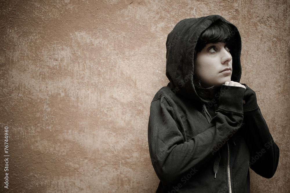 Dark young woman sad standing near urban wall portrait Dark young woman sad standing near urban wall portrait